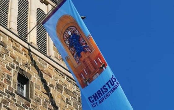 Die Gemeinde hatte Fahnen bedrucken lassen mit einem Bild aus der Attendorner Erlöserkirche: vom Altar und dem darüber befindlichen Fenster mit dem auferstandenen Jesus. Foto: Grote